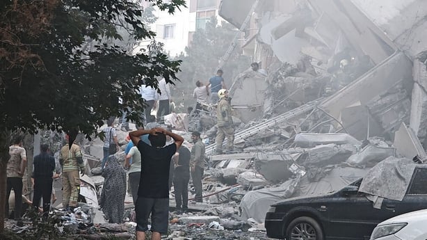 TEHRAN, IRAN - JUNE 13: People look over damage to buildings in Nobonyad Square following Israeli airstrikes on June 13, 2025 in Tehran, Iran. Iran's three top military generals were killed in the attacks that also targeted nuclear and military facilities, according to published reports. Israel desc