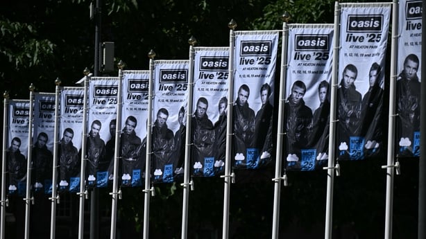 Image shows several flags with a picture of Oasis and details of their concert tour