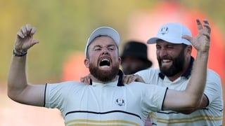 FARMINGDALE, NEW YORK - SEPTEMBER 28: (L-R) Shane Lowry of Team Europe and Jon Rahm of Team Europe celebrate after Lowry's putt to halve the hole and retain the Ryder Cup on the 18th green   during the Sunday singles matches of the 2025 Ryder Cup at Black