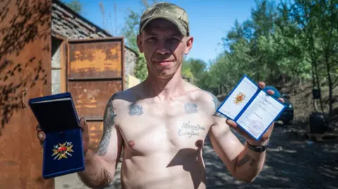 Matthew Goddard/BBC Andrii Andriichuk, a career criminal, shows off his ‘Hero of Ukraine’ medal; the country’s highest honour