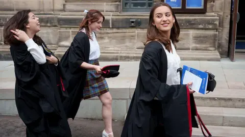 Getty Images Three female graduands make their way through the streets of St Andrews and into a graduation ceremony at the University of St Andrews