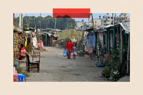 PRAKASH MATHEMA/AFP via Getty Images Residents walk through an informal settlement area in Kathmandu