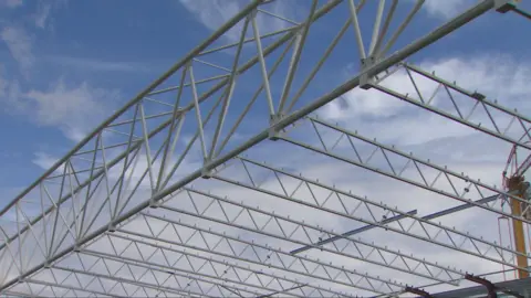 A photo of steel beams against a sky backdrop during the construction of Tynecastle stadium's main stand in 2017.