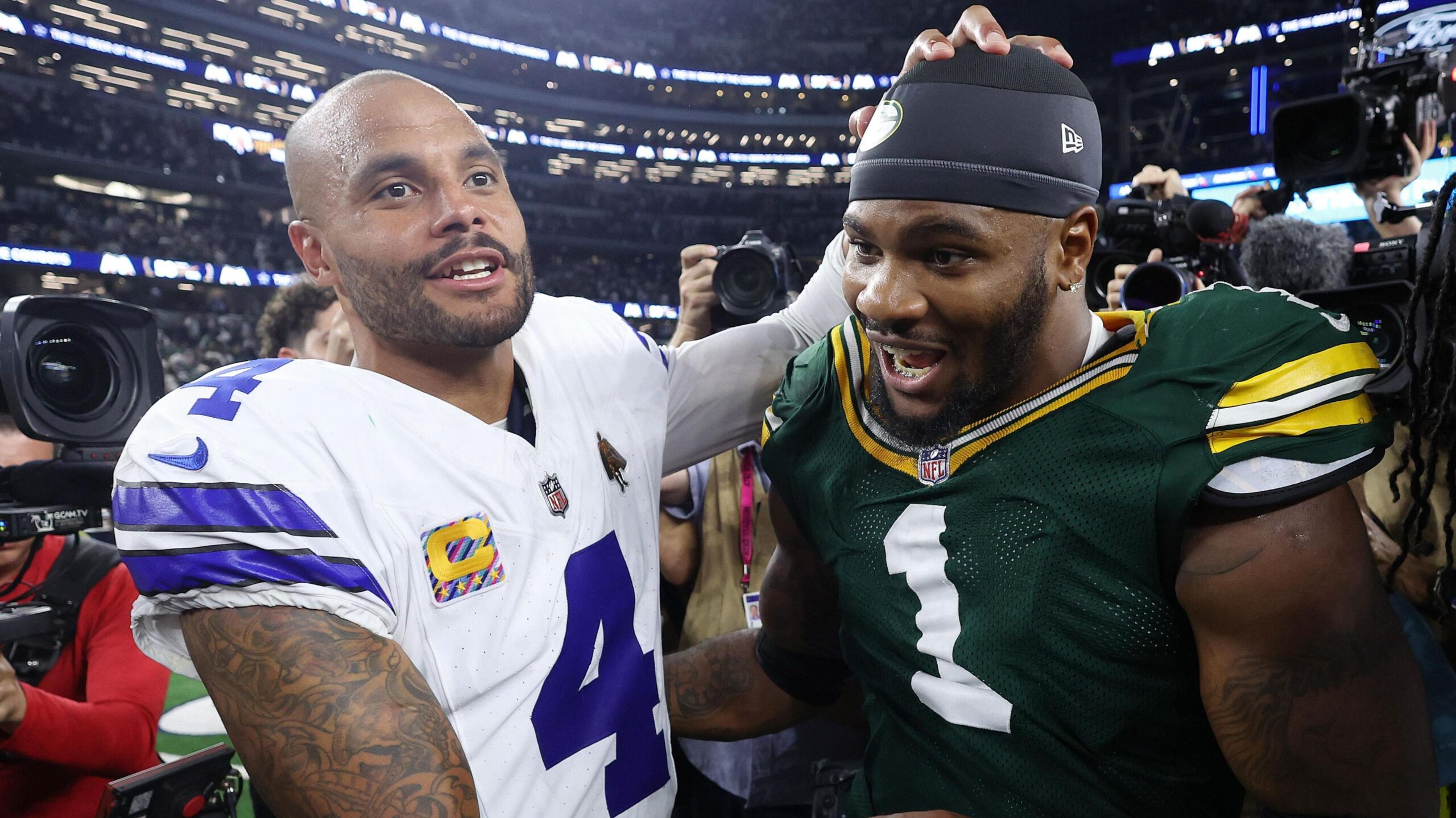 Dak Prescott of the Dallas Cowboys and Micah Parsons of the Green Bay Packers hug after their game in the NFL which ended 40-40