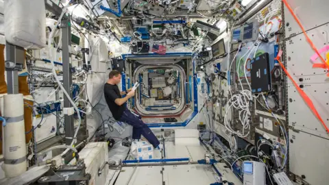 NASA NASA astronaut Reid Wiseman, Expedition 40 flight engineer, reads a procedures checklist in the Destiny laboratory of the International Space Station.