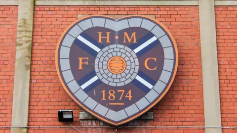Getty Images A photo of Heart of Midlothian FC's crest on a brick wall outside Tynecastle Park.