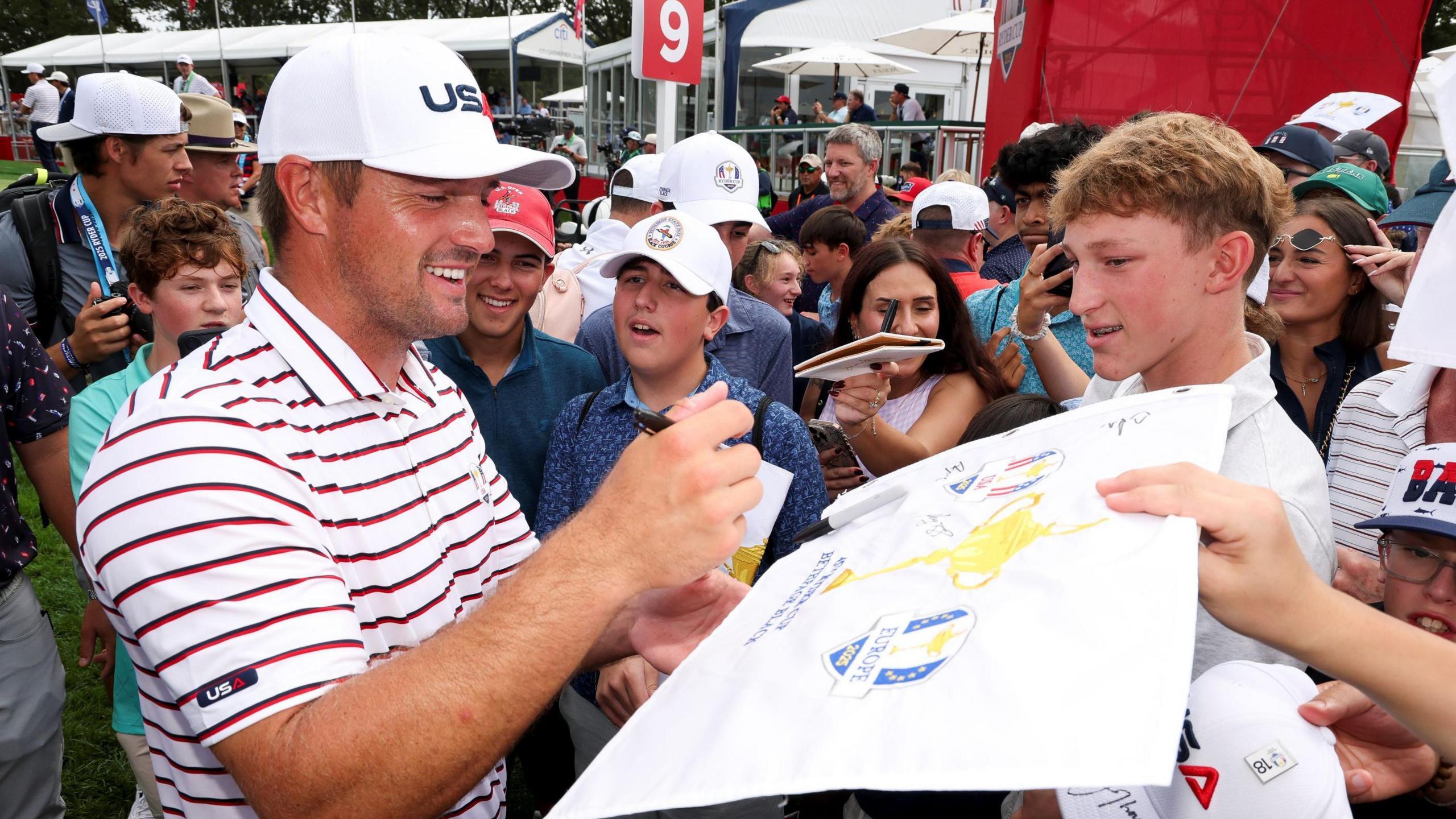 Bryson DeChambeau signs autographs for young fans at the Ryder Cup