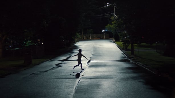 A child runs across a deserted street in Weapons